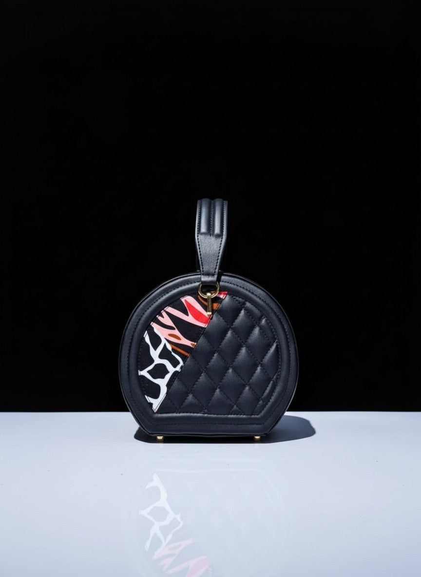 ELVI CREATION Etoile black vegan leather round quilted bag with colourful wax print panels and gold hardware.
