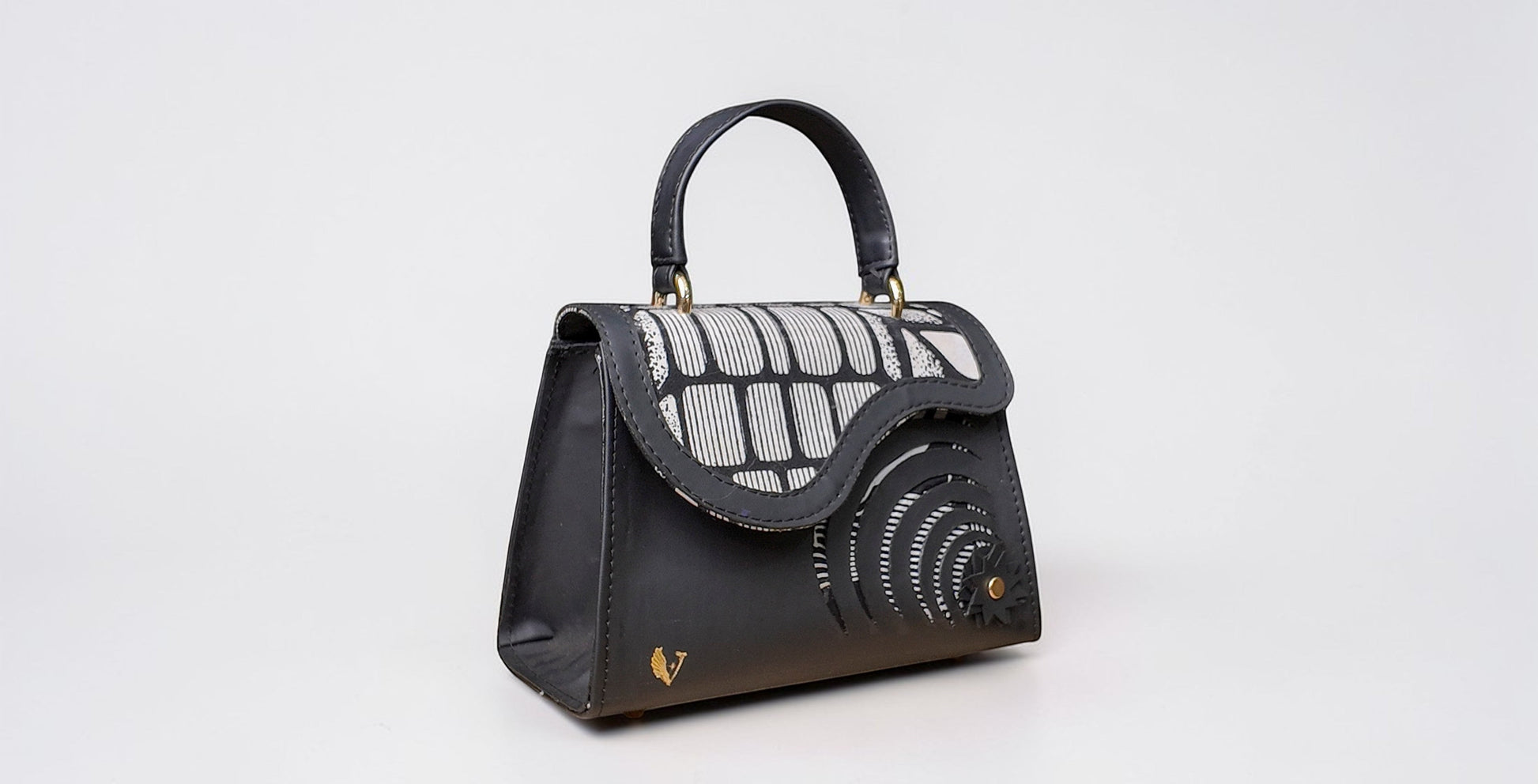 ELVI CREATION Elsha mini black vegan leather handbag with floral appliques and wax lining. Features gold hardware and spiral cutouts.