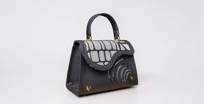 ELVI CREATION Elsha mini black vegan leather handbag with floral appliques and wax lining. Features gold hardware and spiral cutouts.