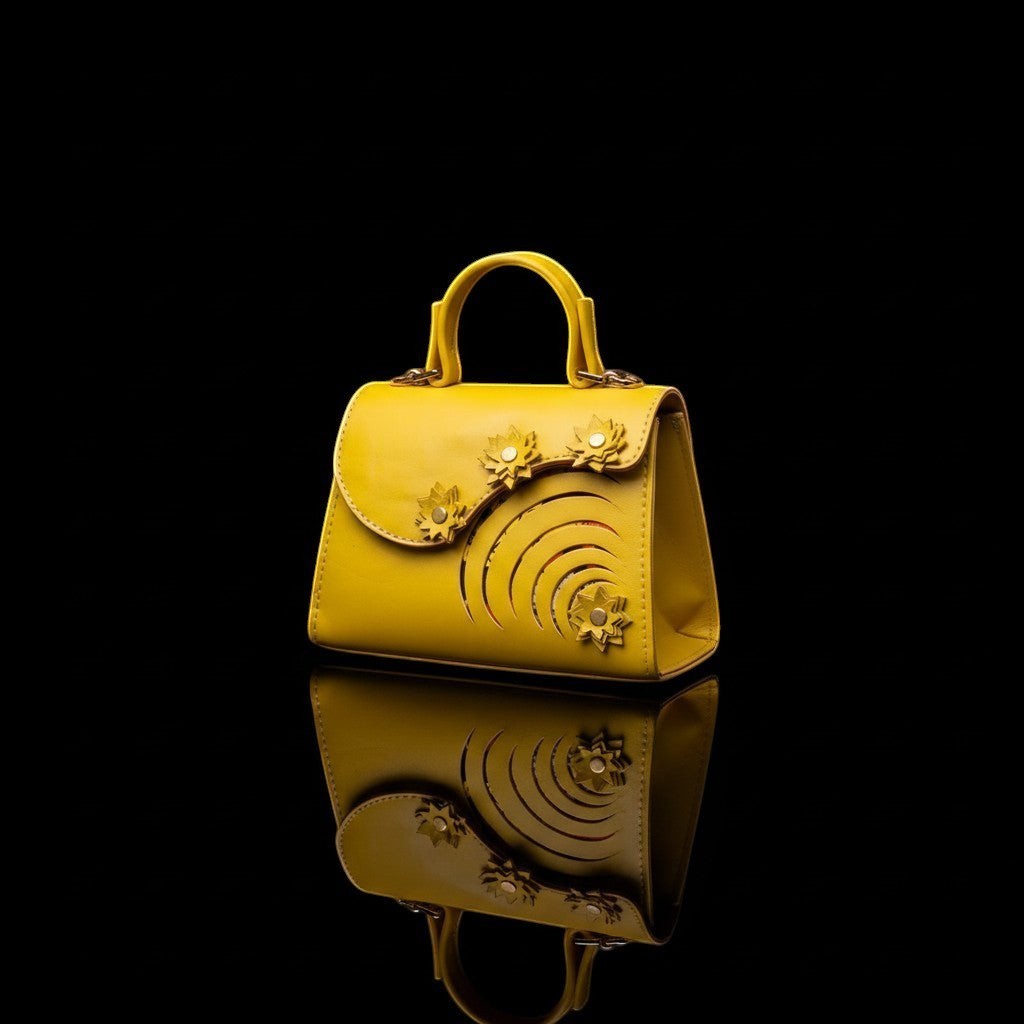 ELVI CREATION Elsha mini yellow vegan leather handbag with floral appliques and spiral cutouts. Gold hardware.