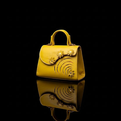 ELVI CREATION Elsha mini yellow vegan leather handbag with floral appliques and spiral cutouts. Gold hardware.