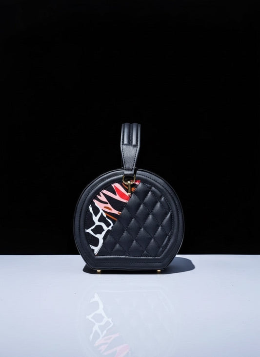 ELVI CREATION Etoile black vegan leather round quilted bag with colourful wax print panels and gold hardware.