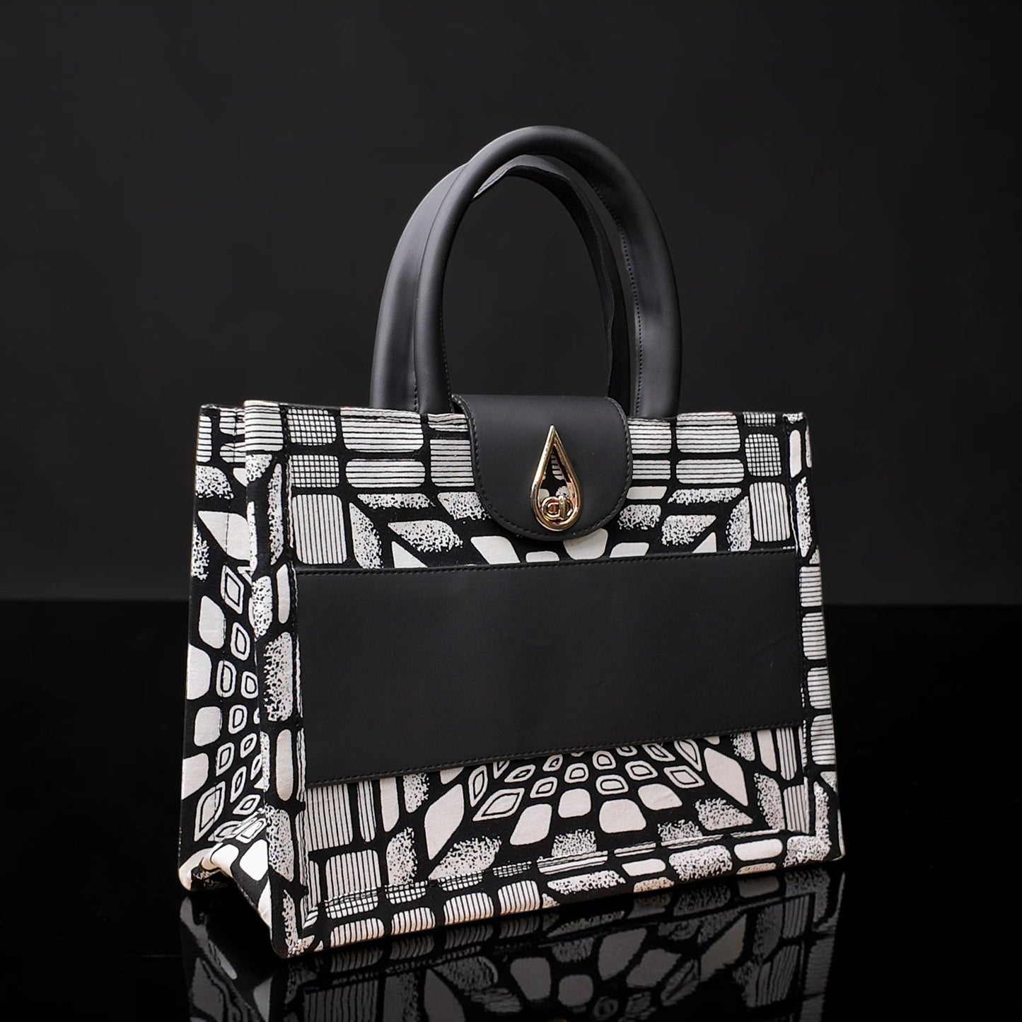 ELVI CREATION KODJO tote bag with black and white geometric African print, black vegan leather accents, and gold hardware.