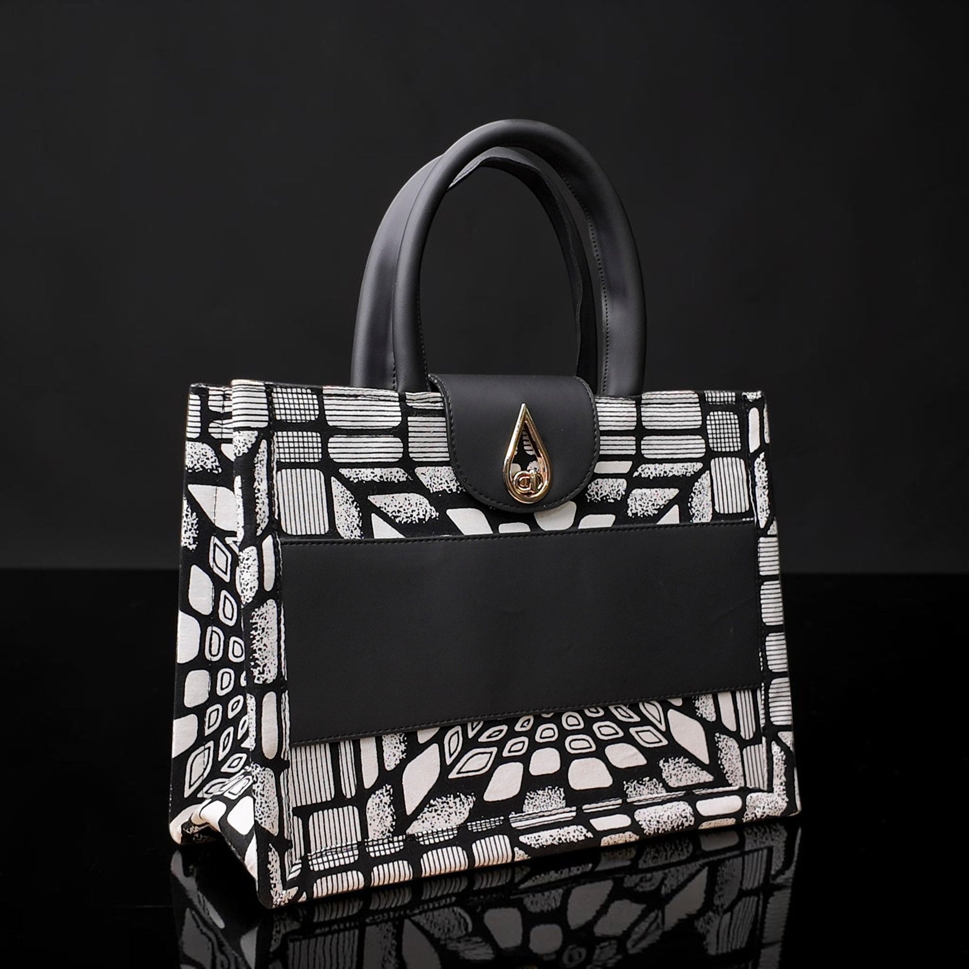 ELVI CREATION KODJO tote bag with black and white geometric African print, black vegan leather accents, and gold hardware.