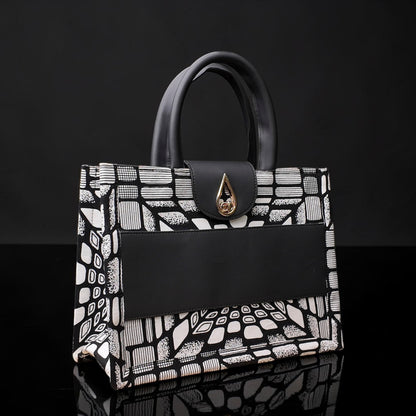 ELVI CREATION KODJO tote bag with black and white geometric African print, black vegan leather accents, and gold hardware.