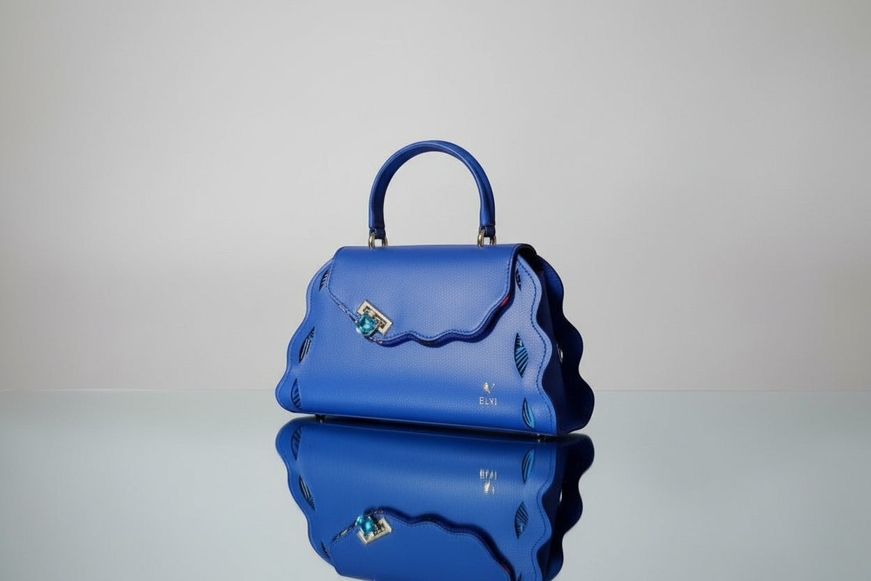 ELVI CREATION Trésor royal blue vegan leather handbag with wavy edges and gold hardware. Jewel clasp.