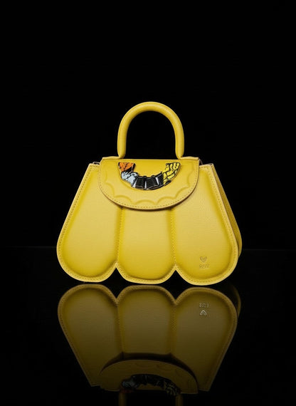 ELVI CREATION yellow vegan leather Cupidon handbag with sculpted petal design and gold hardware. Includes detachable strap.
